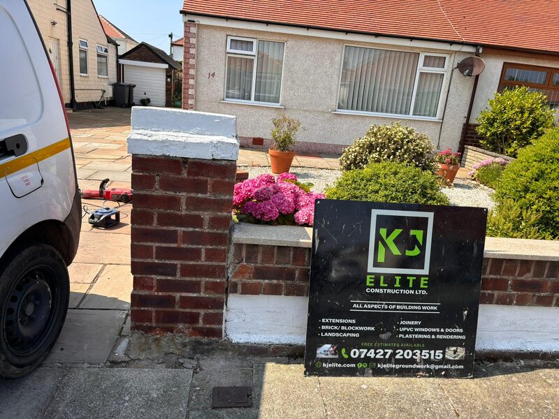 Brick front wall and pillar with KJ Elite Construction sign at bungalow project