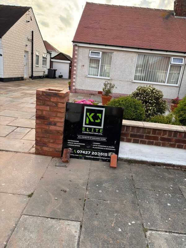 Brick pillar and patio with KJ Elite Construction signboard at bungalow