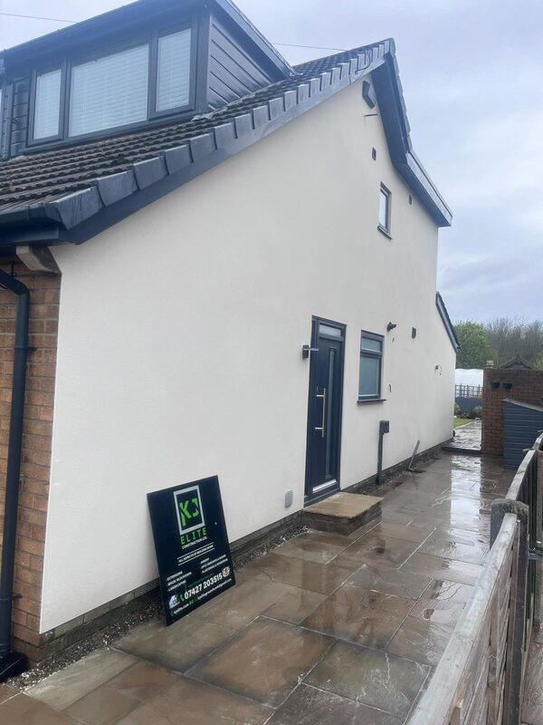 Completed rendered house extension with new door and stone patio by KJ Elite Construction