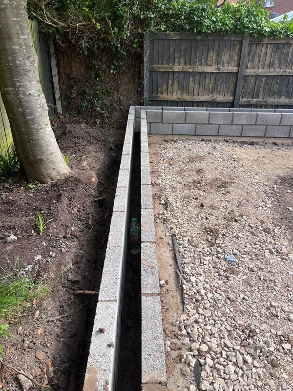 Concrete block edging and kerb being laid for garden raised beds
