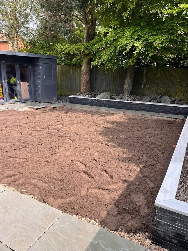 Garden groundwork preparation with raised bed borders and levelled soil