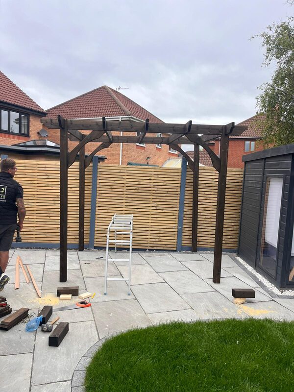 Timber pergola being built on stone patio with new fencing by KJ Elite Construction