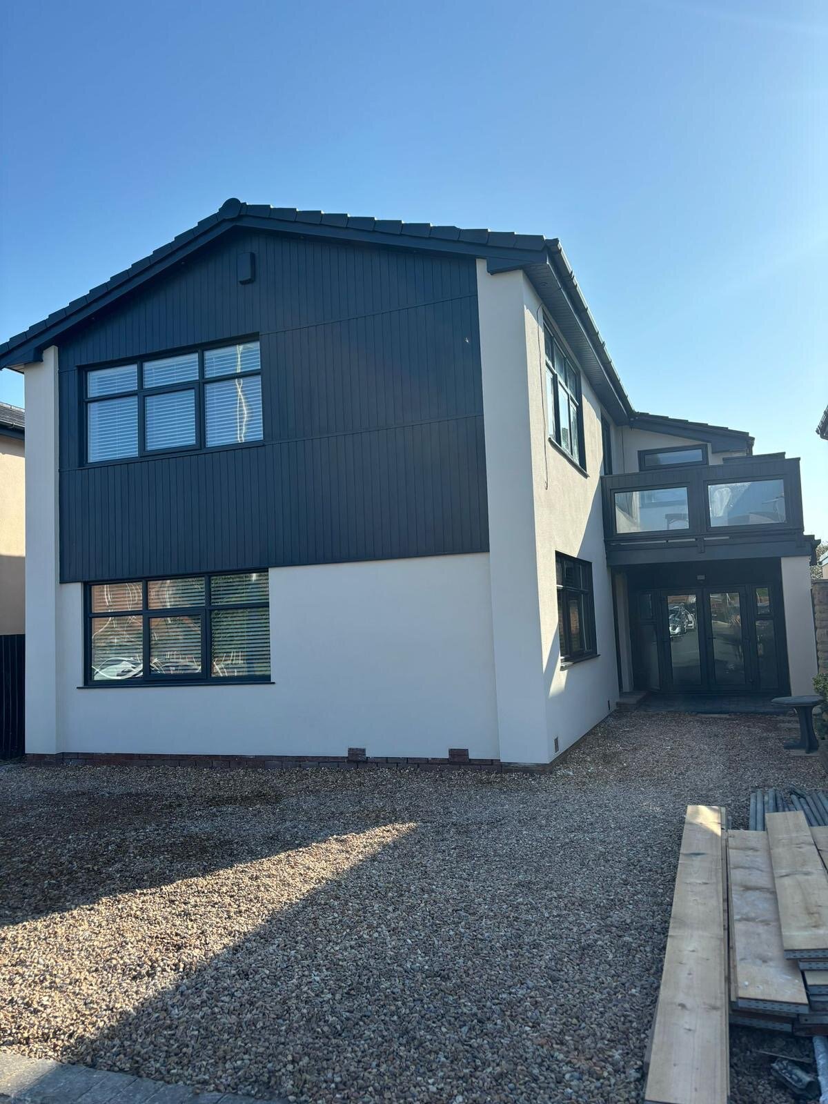 Modern house renovation with dark cladding and white render in Blackpool by KJ Elite Construction